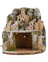 Illuminated snow-covered nativity scene with village and cave