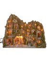 Illuminated nativity scene with cave, fountain, waterfall and fire