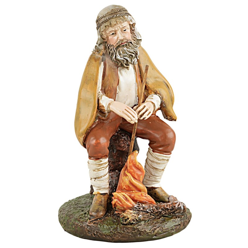 Shepherd with staff sitting in front of the fire in painted resin