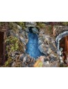 Illuminated nativity scene complete with statues, waterfall, fountain, and